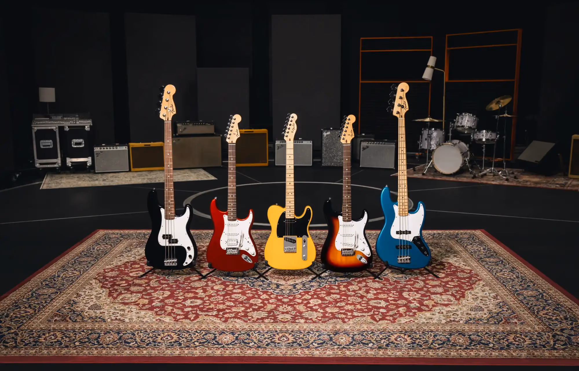 A sunburst electric guitar's full body and neck, lit against a dark studio background, showing the complete instrument before any signal chain begins.