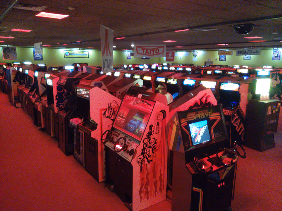 Rows of illuminated arcade cabinets lined up inside the American Classic Arcade Museum