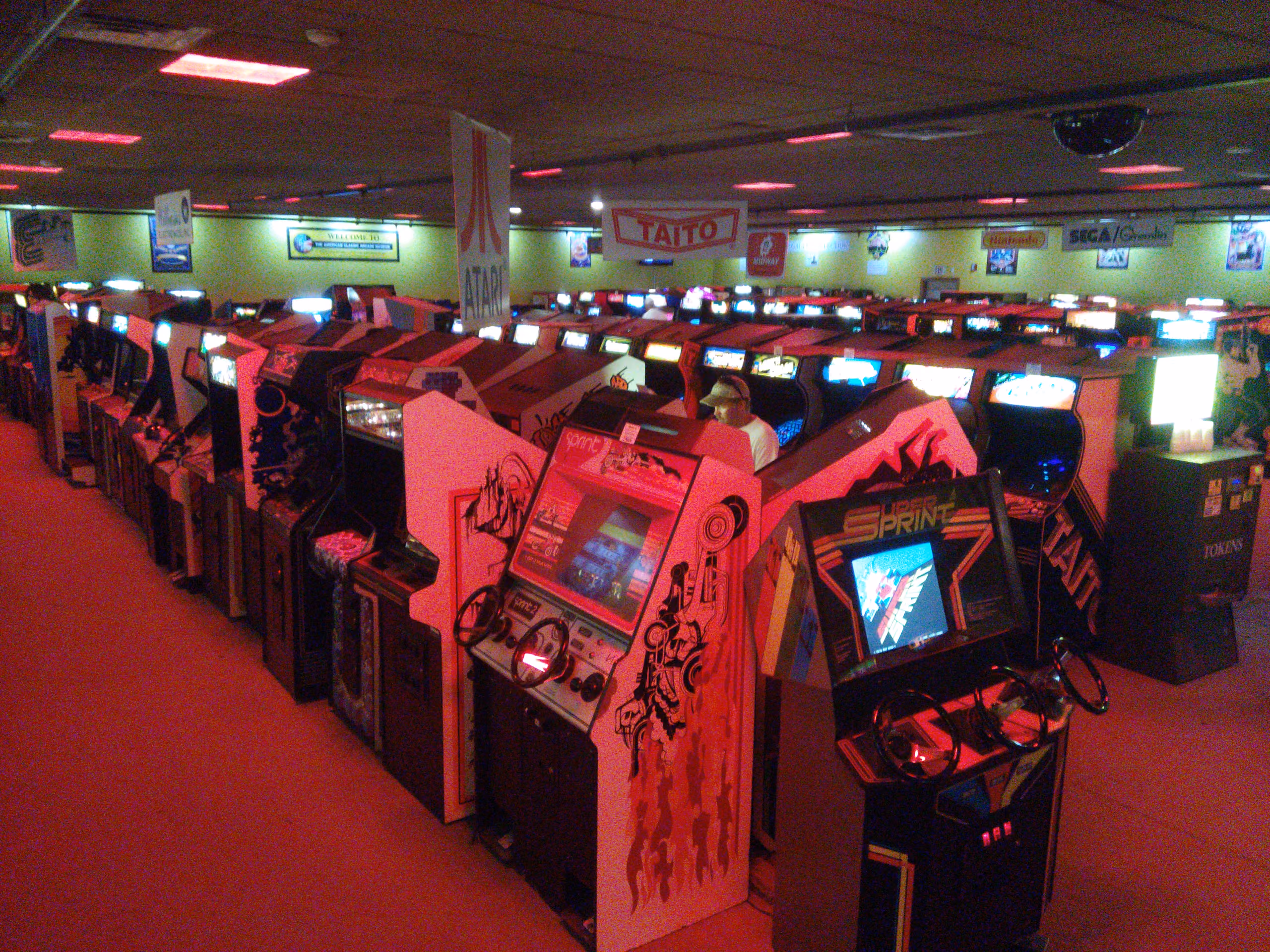 Rows of illuminated arcade cabinets lined up inside the American Classic Arcade Museum