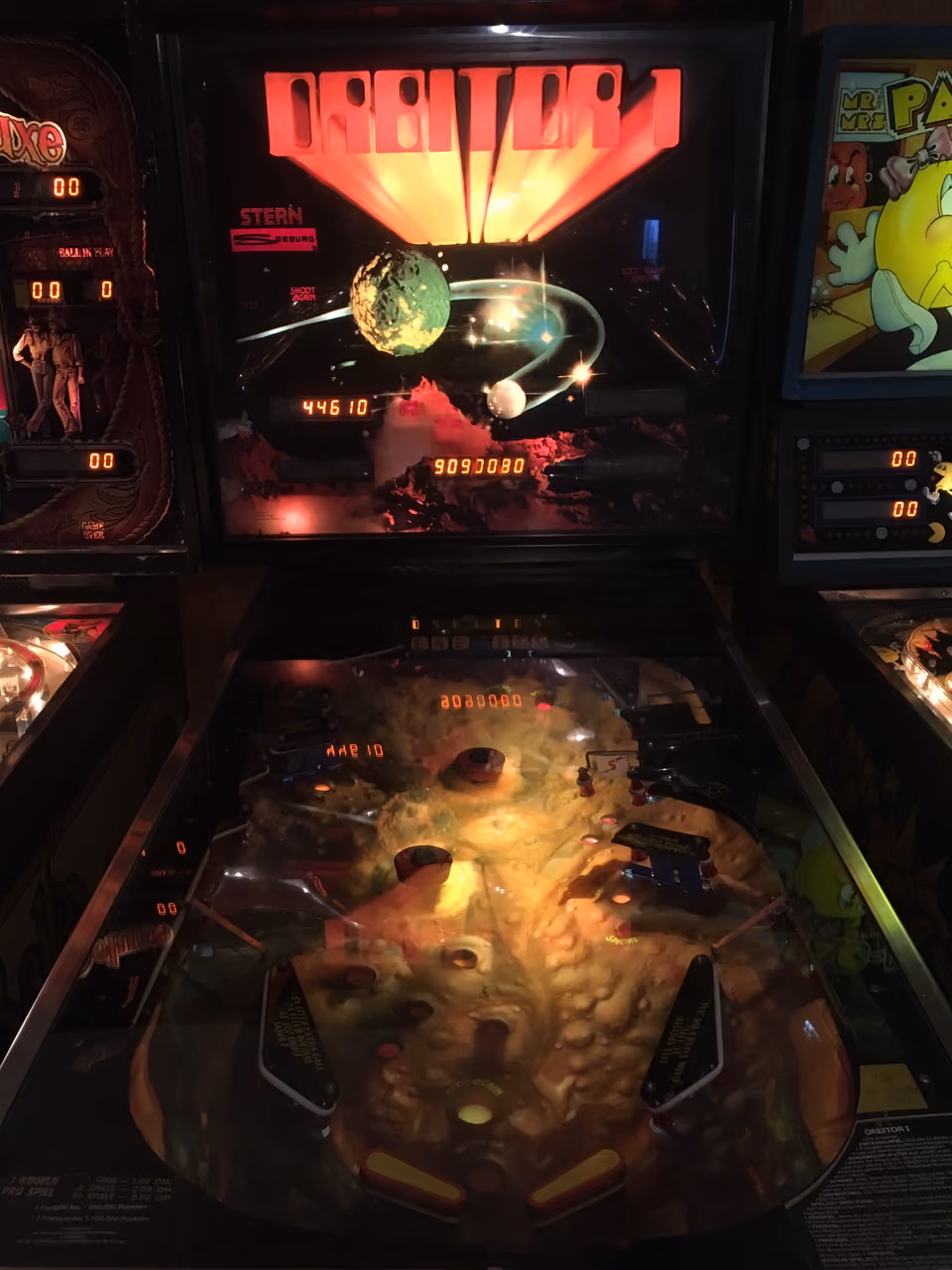 A pinball machine's illuminated playfield, full of lights, ramps and bumpers built to make every hit felt