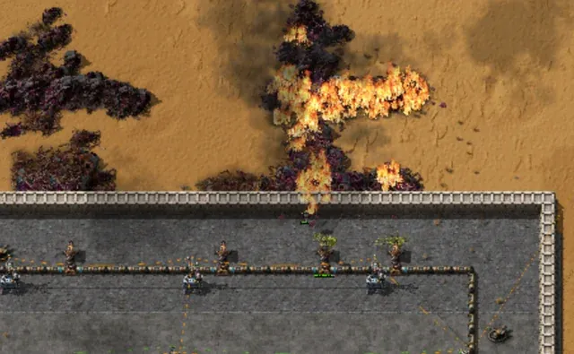 A wiki screenshot of a flamethrower turret spraying a stream of fire across a wall of approaching biters along a factory's perimeter