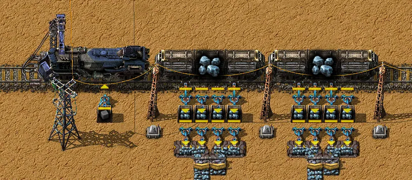 A train station with a locomotive and two wagons, inserters and chests loading and unloading ore automatically