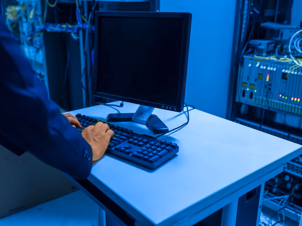An IT technician working among server racks in a data centre