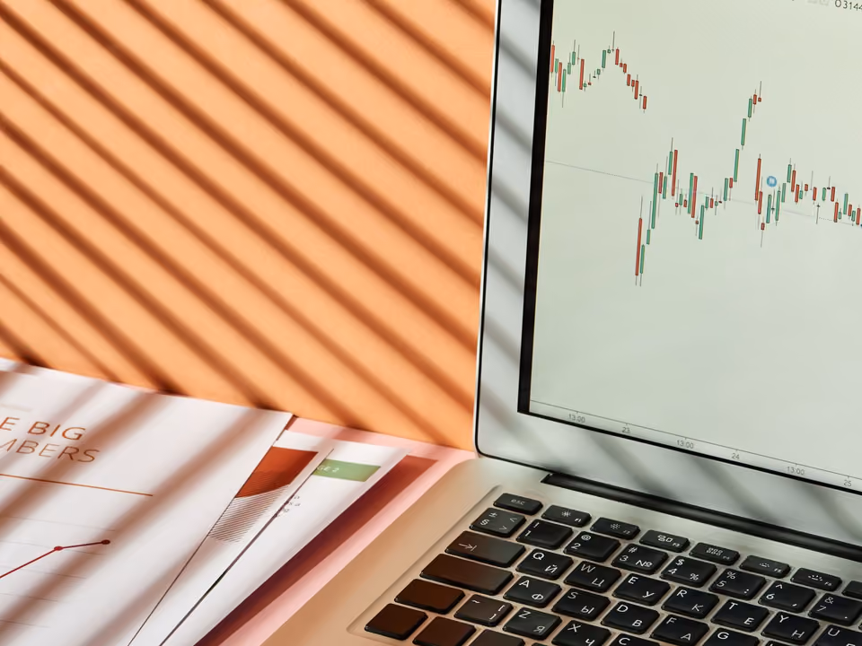 A laptop displaying a stock exchange graph