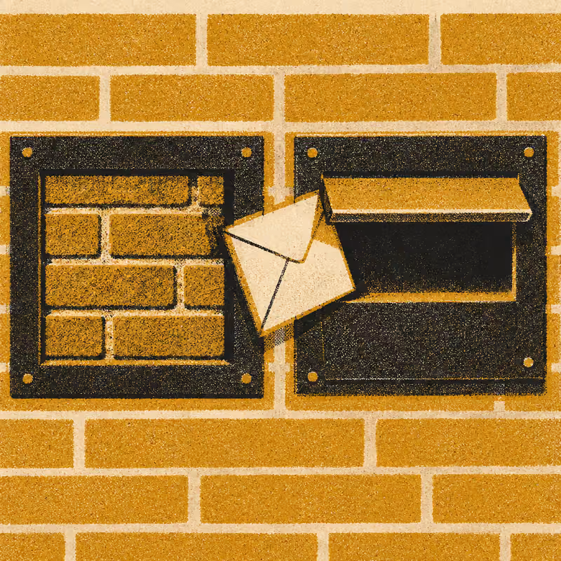 An envelope caught between two mail slots side by side, one bricked shut, the other open