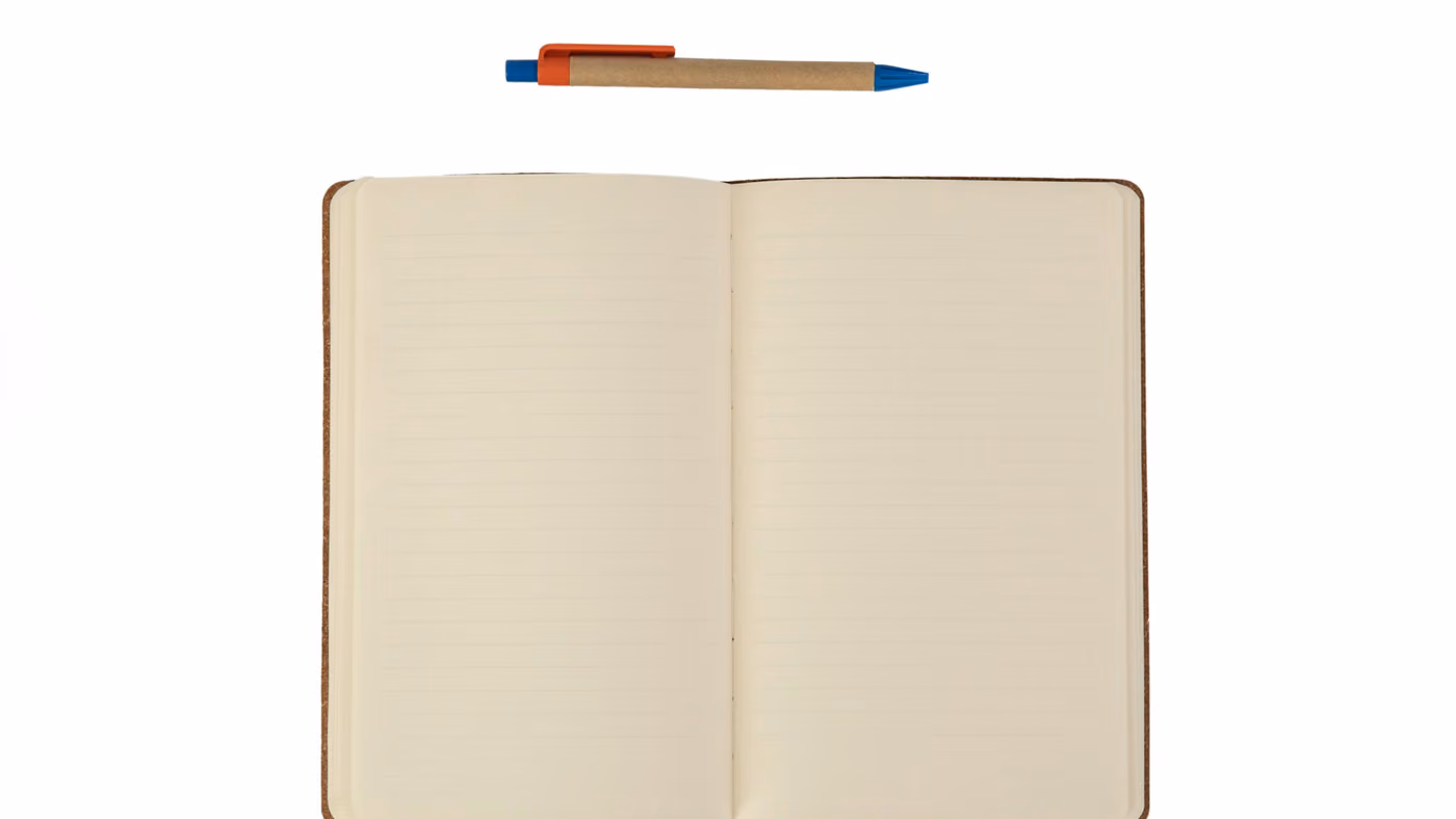 An open notebook of lined pages with a ballpoint pen resting above it