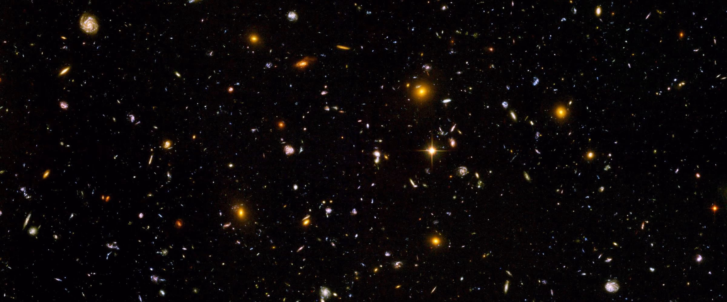 A narrow strip of the Hubble Ultra Deep Field: thousands of distant galaxies in a patch of sky that looks black to the eye.