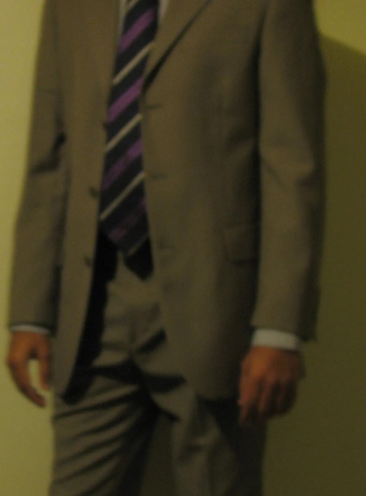 Overdressed outfit: a full suit with a bold black-and-purple striped
tie, seen from the collar down