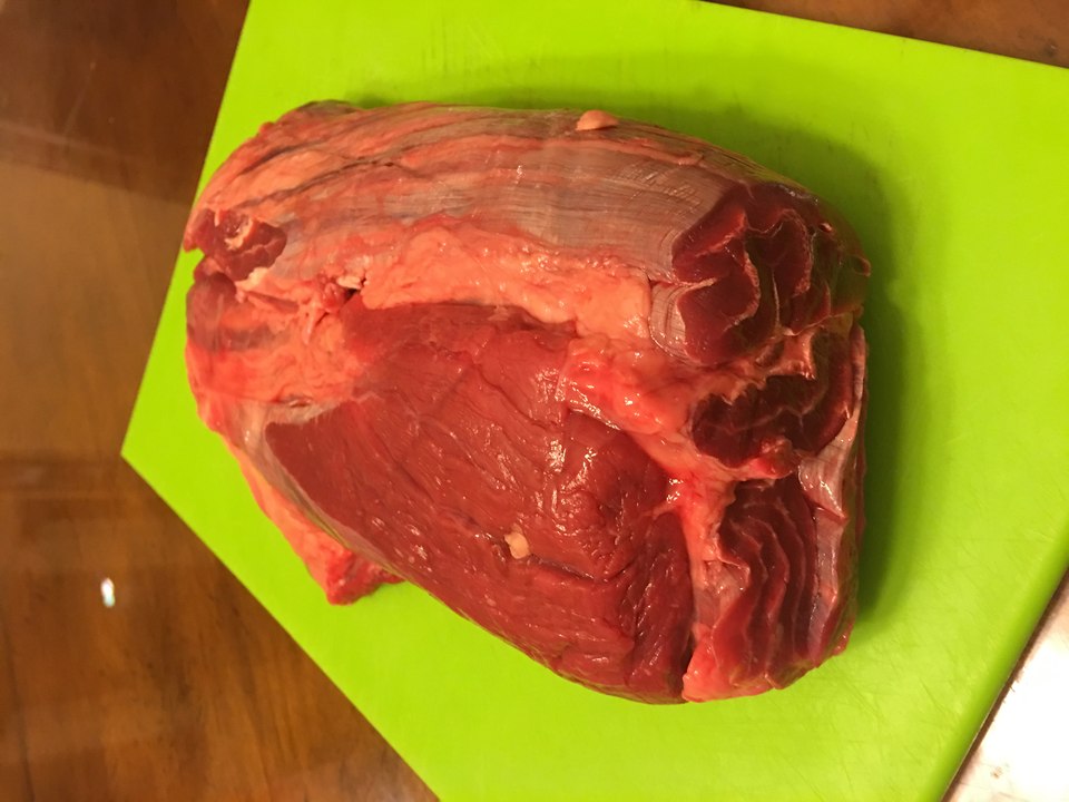 A raw beef shank cross-section, a worked cut with coarse muscle grain and a visible band of connective tissue