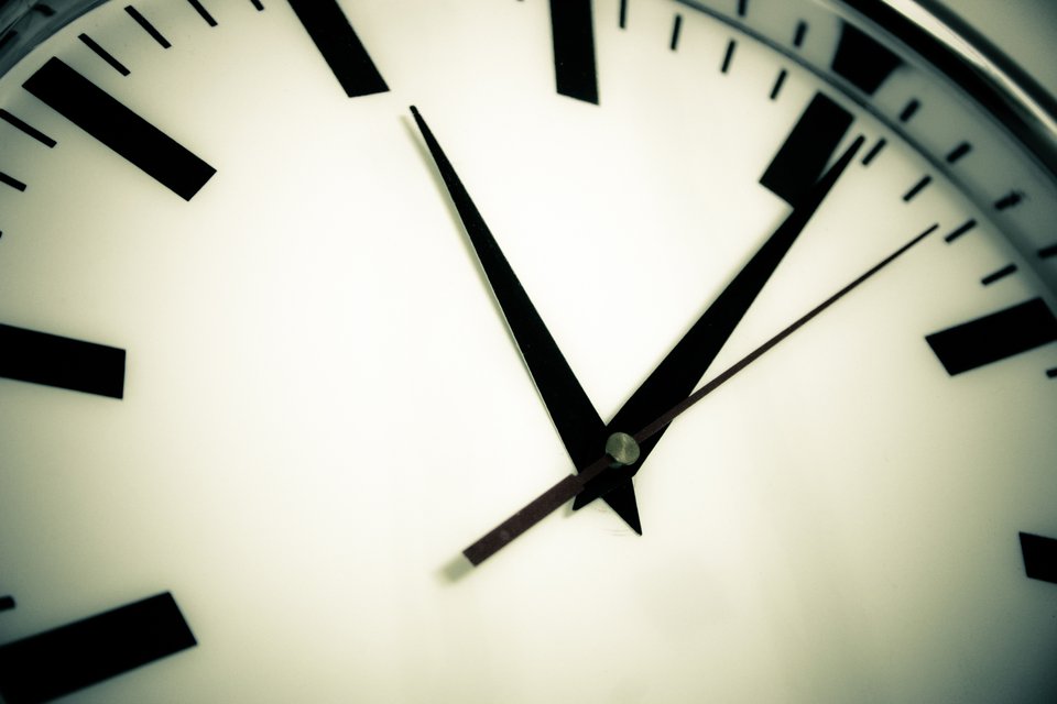 A close-up of an analogue clock face, the check against which the ninety minutes in this worked example is measured