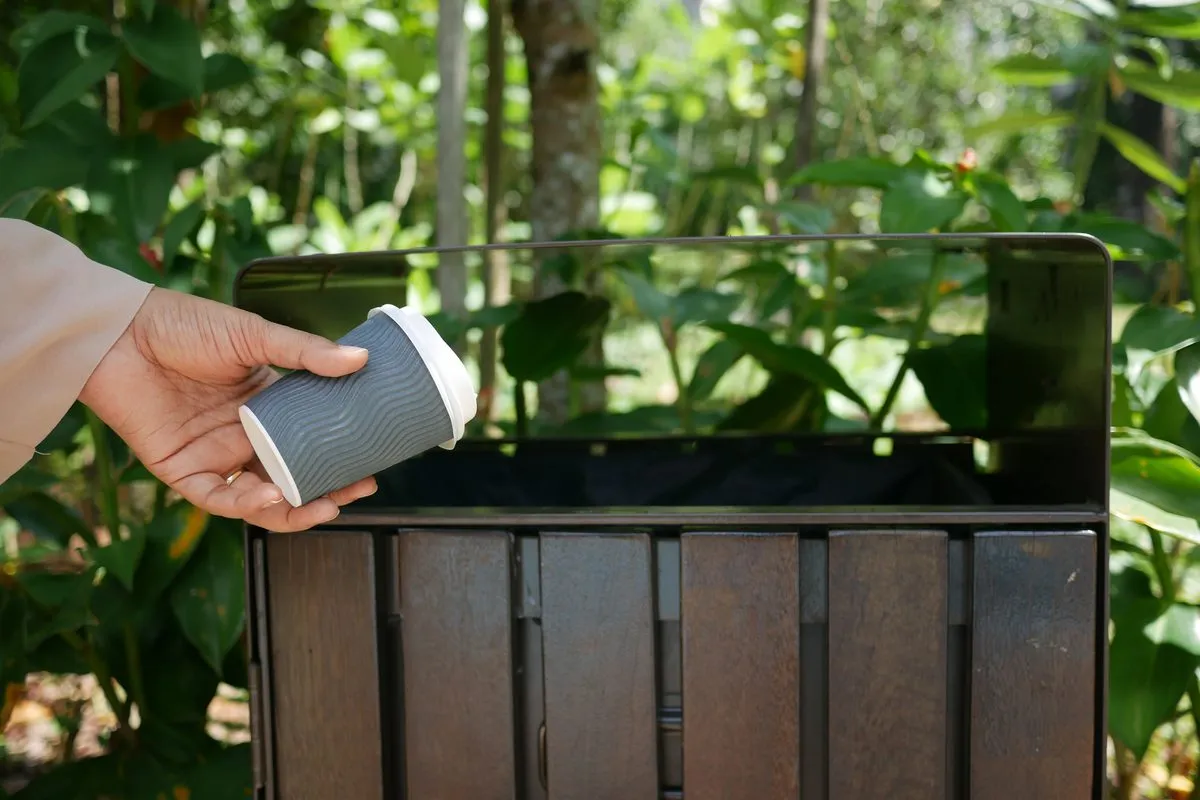 Good manner: a hand places a cup directly into a public
bin.