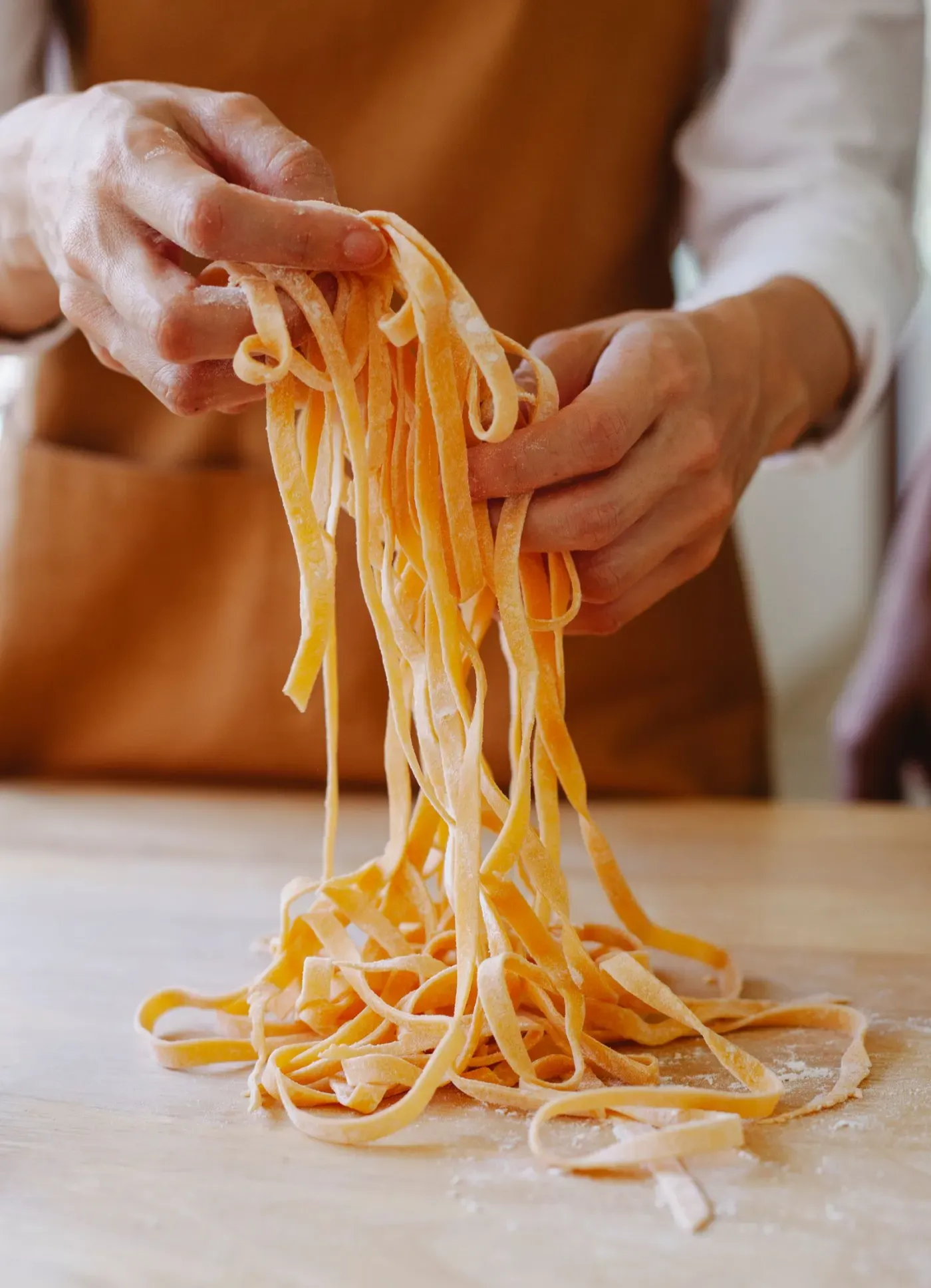 Close-up of hand-pulled wheat noodle dough being stretched